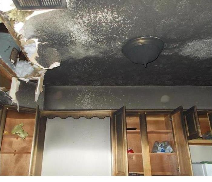 Fire and soot damage on a ceiling that has caused it to partially cave in